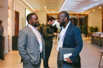 Two people in suits chatting at London Summit 26